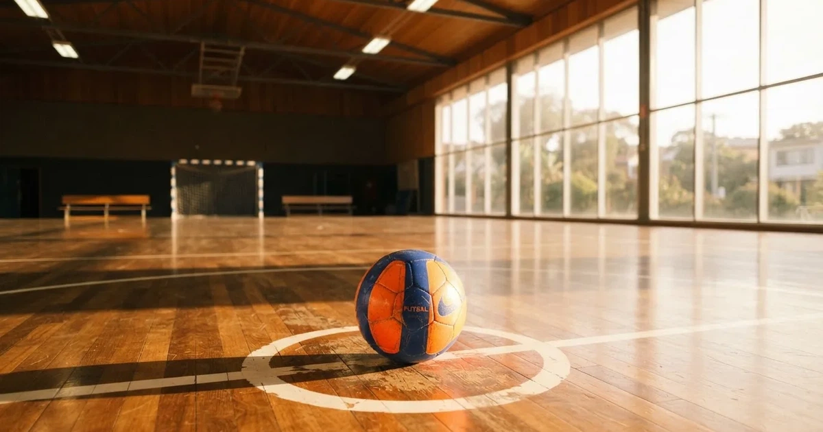 Un balón en el punto central de un campo de césped a la luz de la mañana