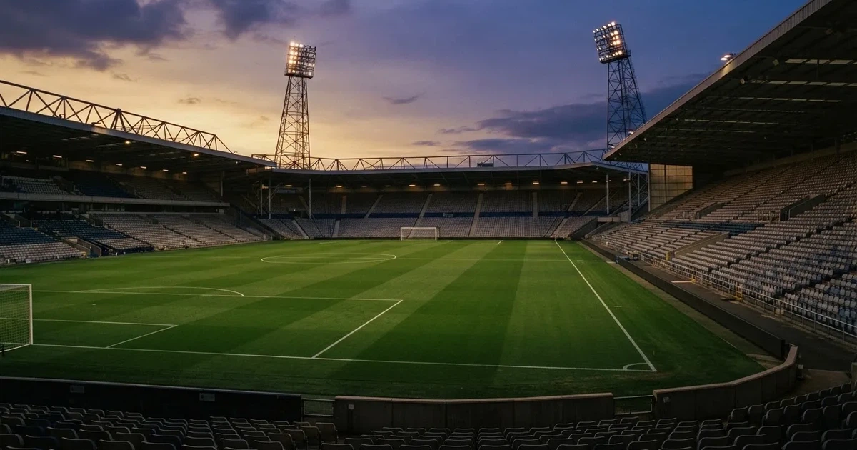 Un estadio de fútbol vacío con torres de iluminación al atardecer