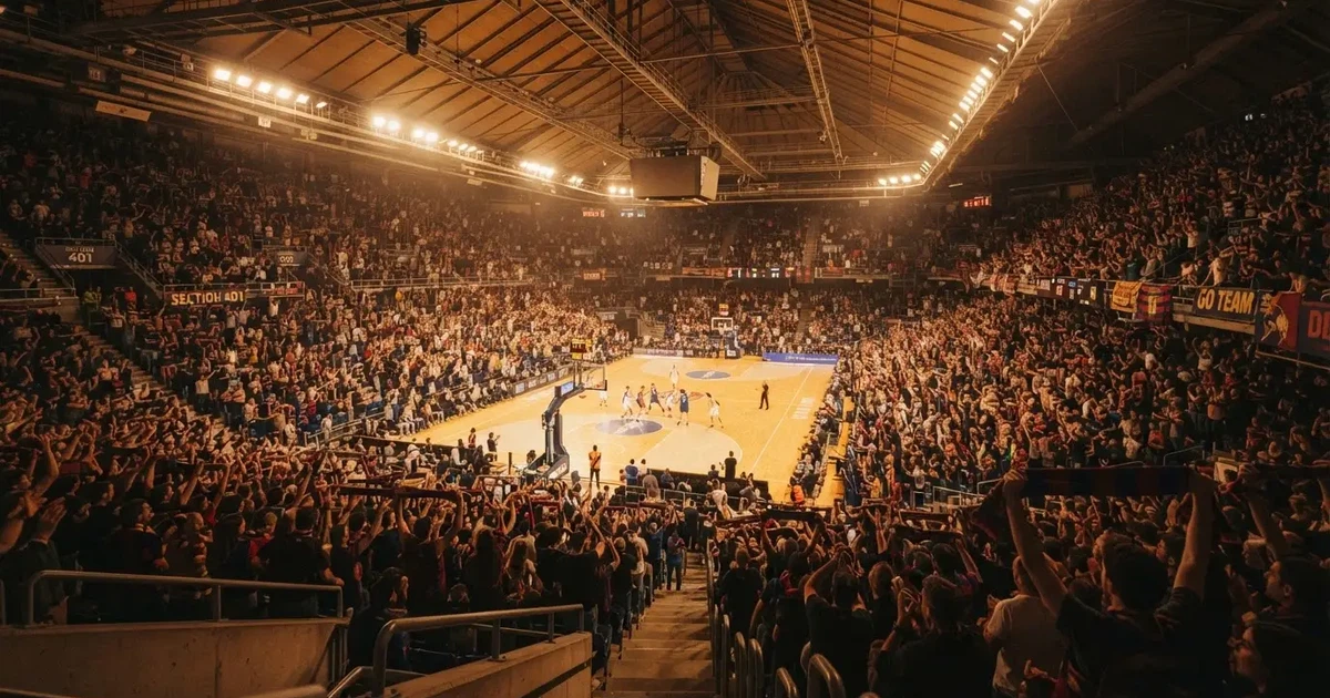 Un pabellón deportivo lleno bajo los focos, fotografiado desde muy lejos
