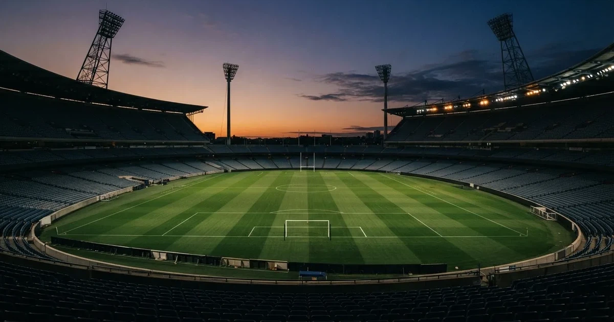 Un estadio de fútbol vacío con torres de iluminación al atardecer